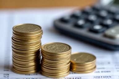 Stack of coins and a calculator symbolizing pension planning.